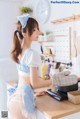 A woman in a blue and white dress is cooking in a kitchen.