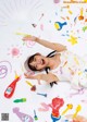 A woman laying on the ground covered in paint.