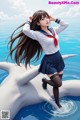 A woman in a school uniform standing on top of a dolphin.