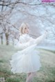 A woman in a white dress standing in a field of flowers.