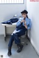 A woman in a blue uniform sitting on a chair.